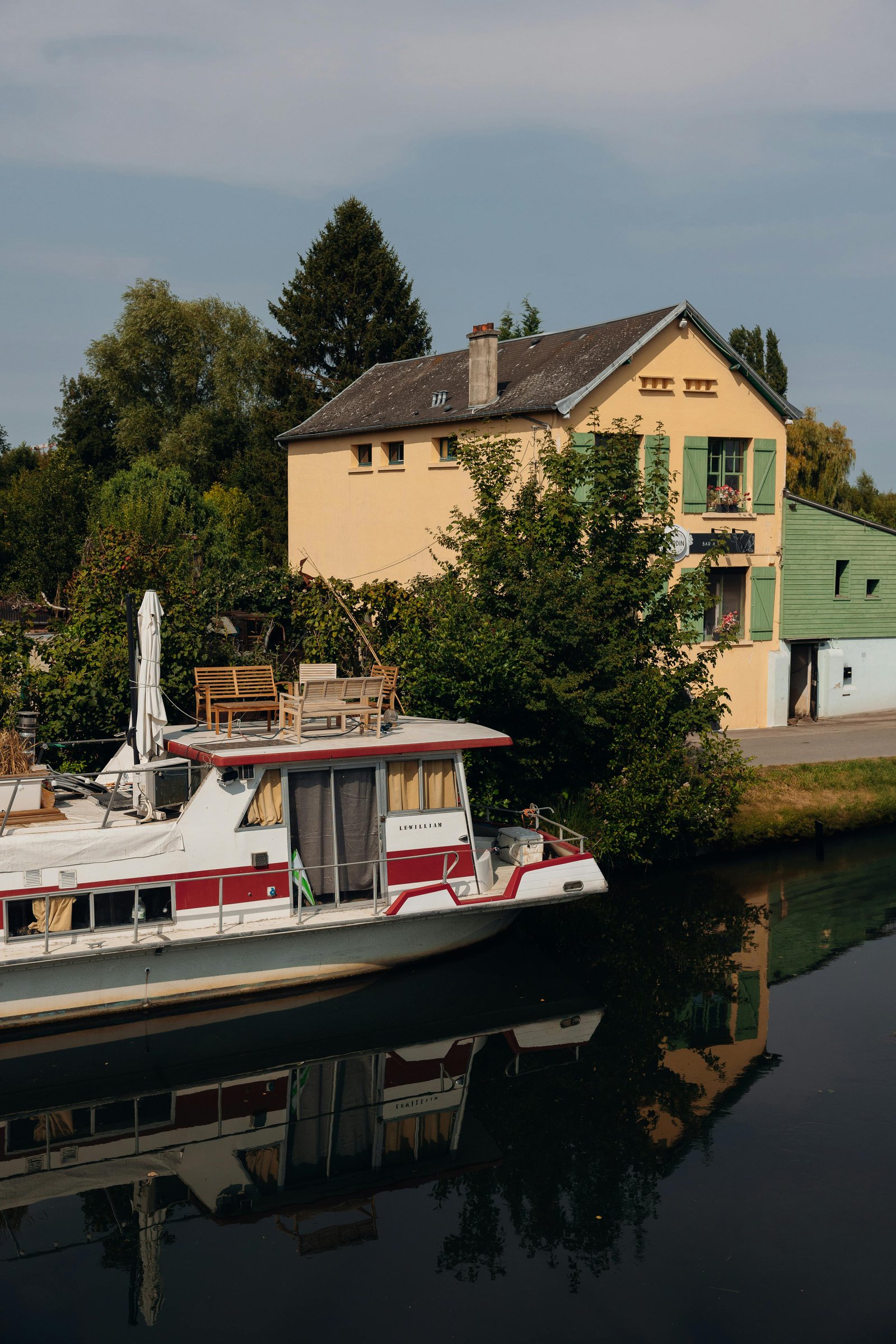 Maison éco-conçue entourée de verdure, illustrant l’intégration de matériaux durables et d’énergies renouvelables.
