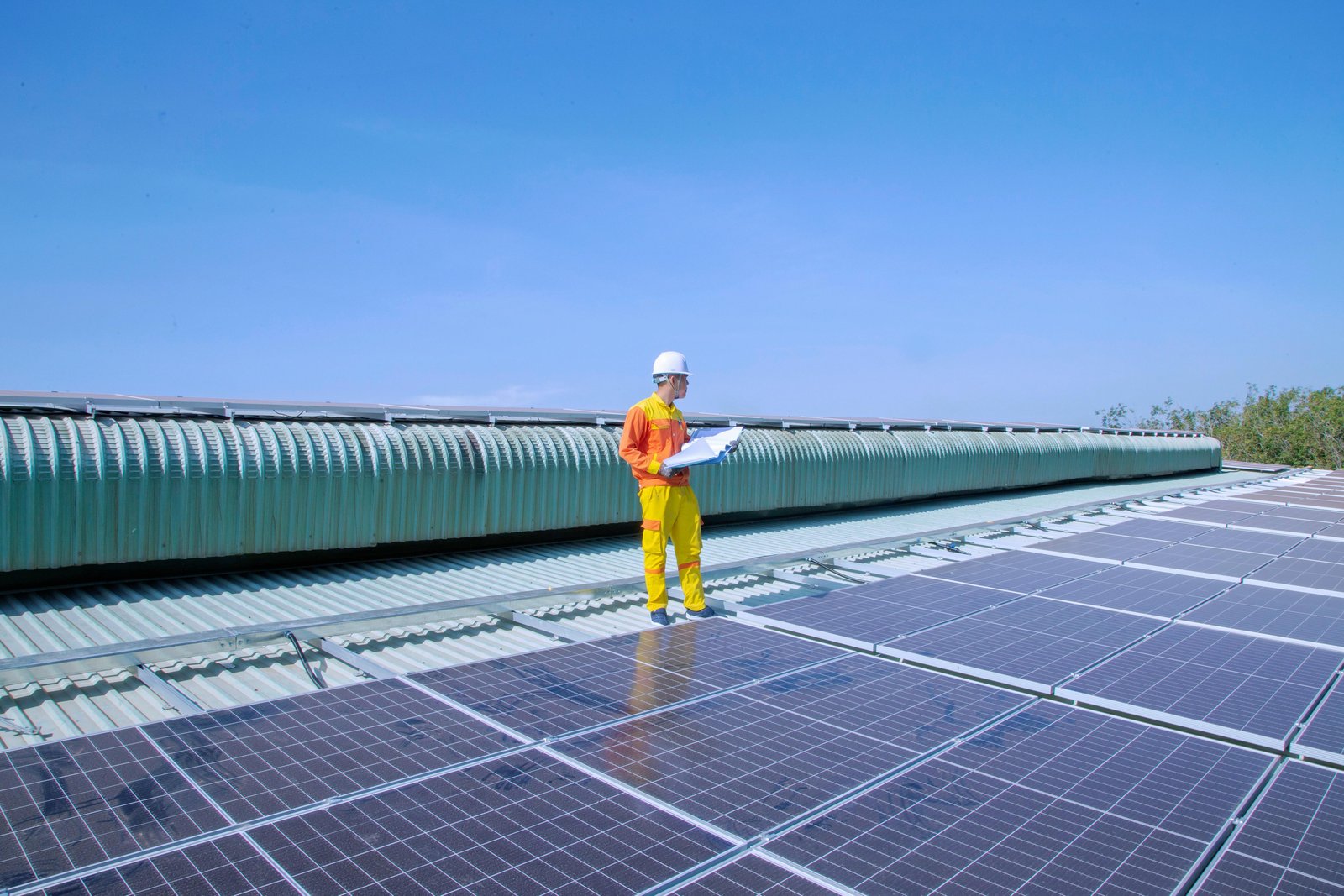 Ouvriers installant des panneaux solaires sur le toit d'une maison rénovée